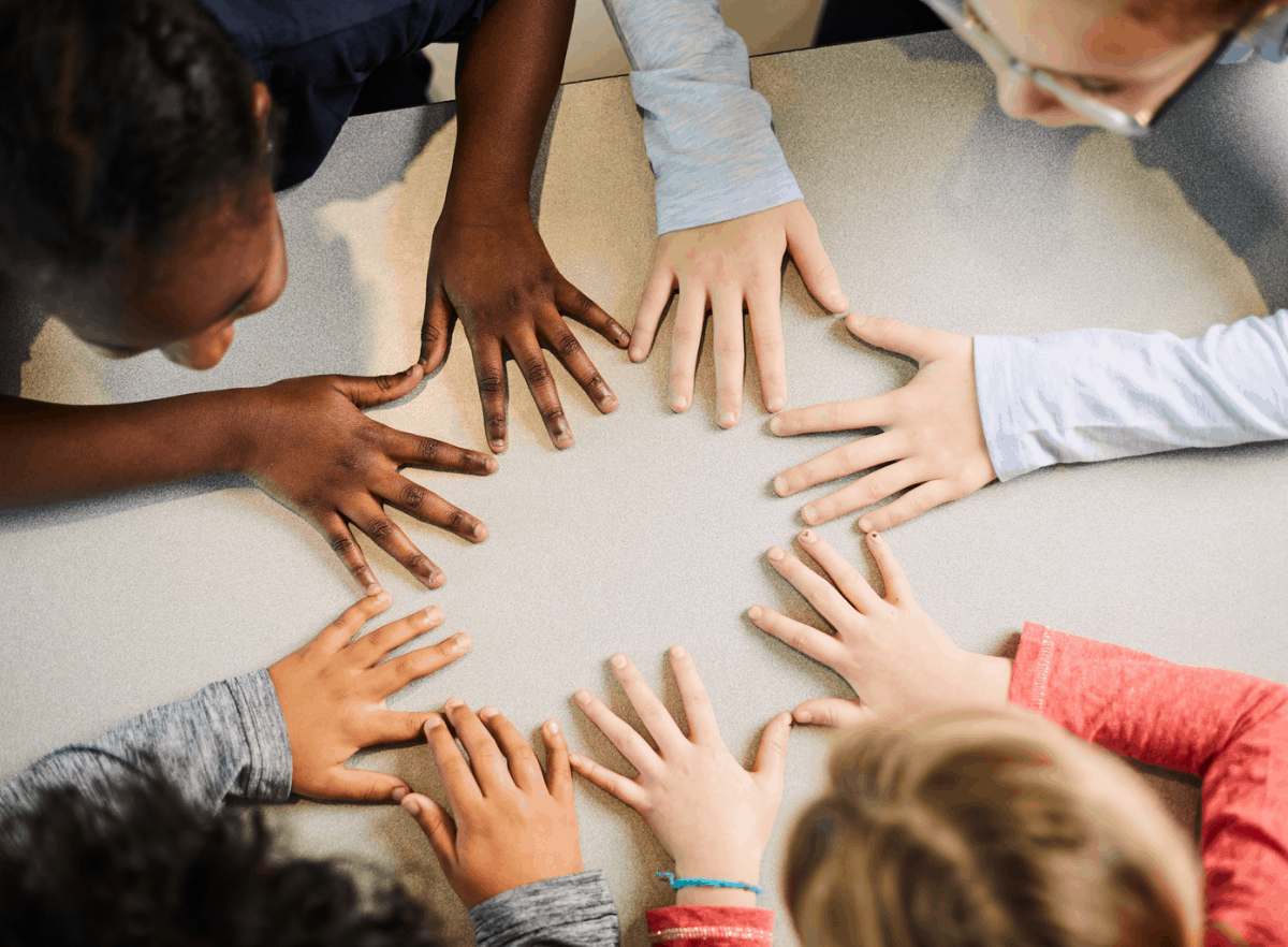 Kids putting hands together on the table